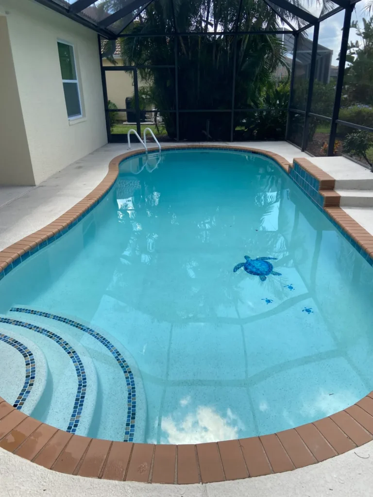 A round pool with mosaic turtle designs and curved steps inside a screened lanai.
