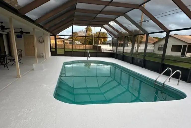 A screened-in rectangular vinyl pool with a covered patio area under a cloudy sky.