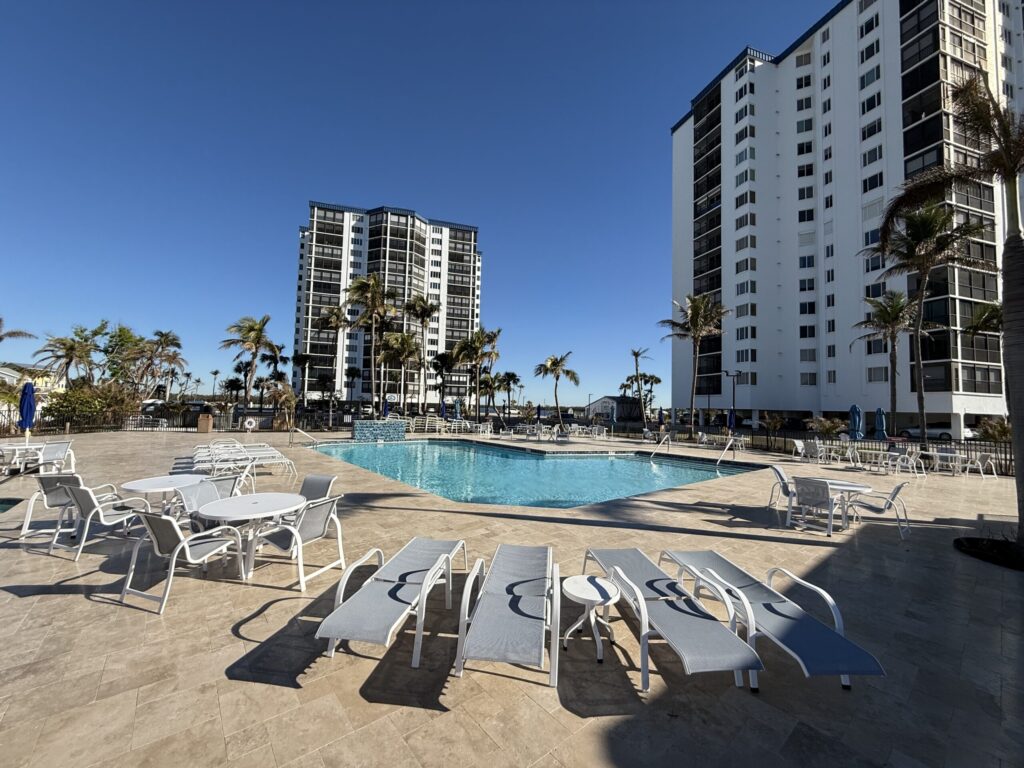 A geometric pool surrounded by loungers at a high-rise condominium complex.