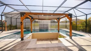 Rectangular pool under a screened lanai with a wooden pergola shade structure and a sheer descent water curtain feature over a sunken seating area.