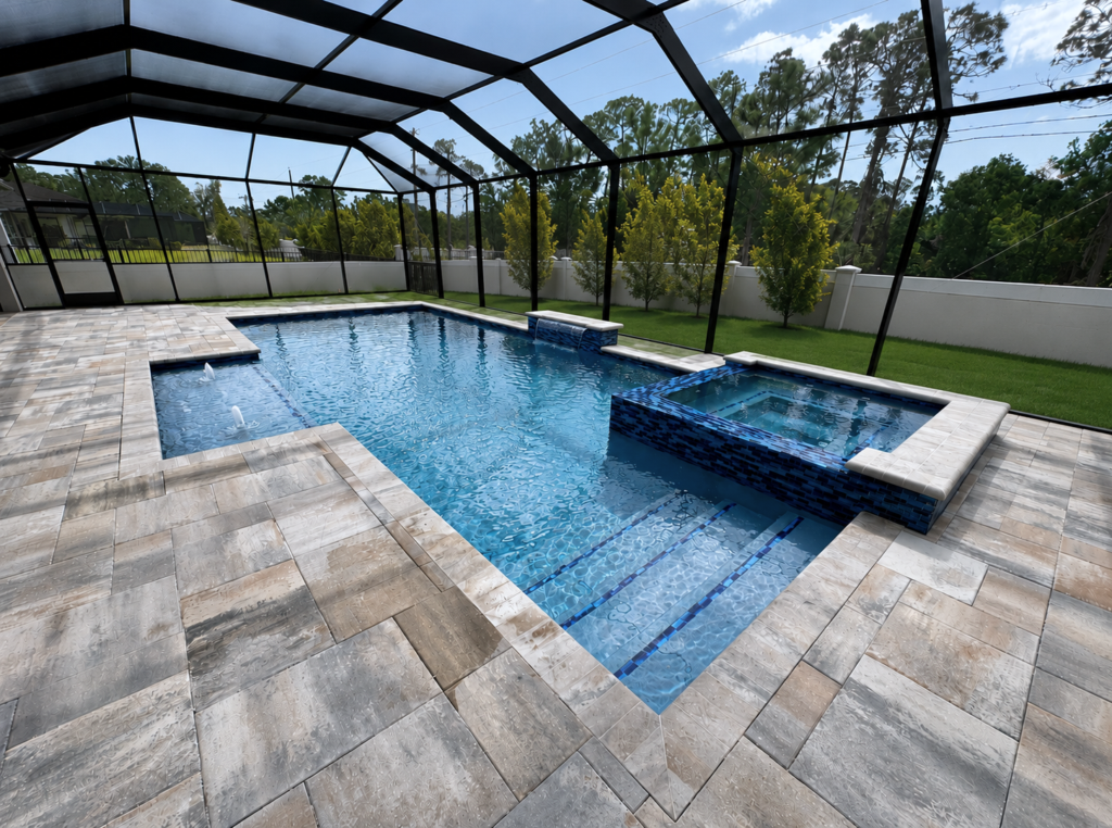 A rectangular gunite pool with a raised tiled spa under a screened enclosure and paver deck.