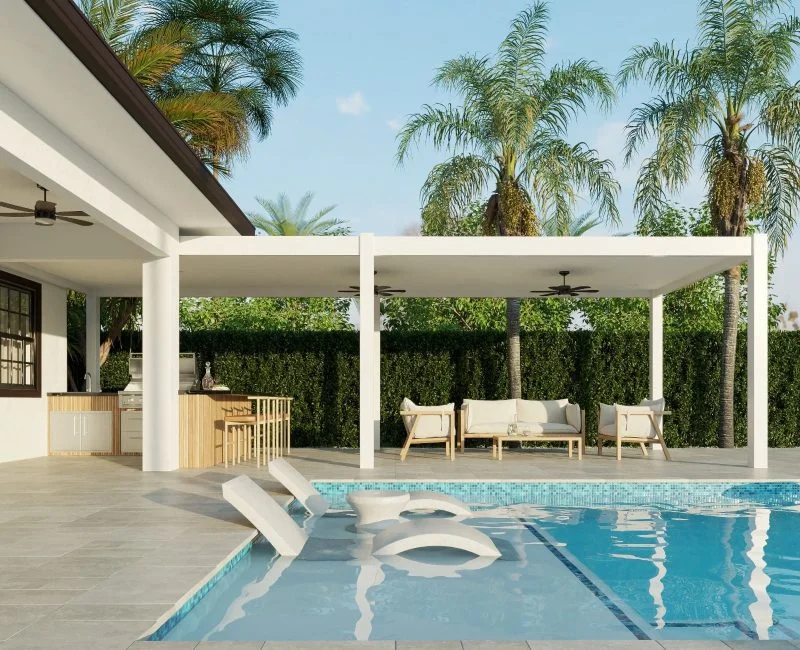 A corner of a backyard pool with floating loungers, beside a covered outdoor kitchen and lounge area.