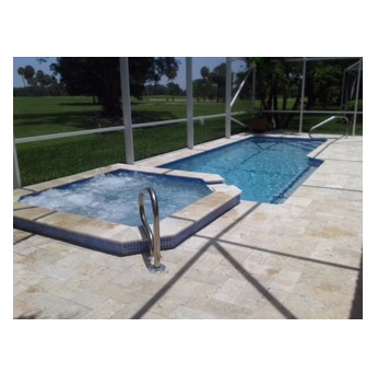 A rectangular pool with an attached raised spa under a screened lanai overlooking a golf course.