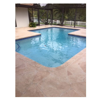 An L-shaped backyard pool with a stamped concrete patio under a screened enclosure.
