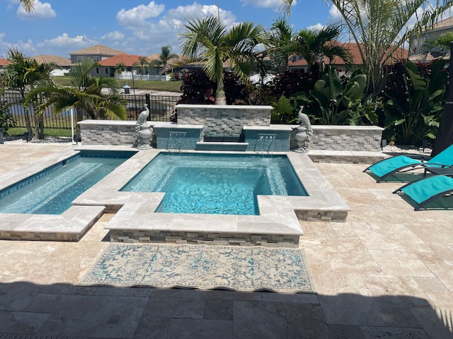 A geometric pool with a raised stacked-stone water feature wall and travertine deck overlooking a canal.